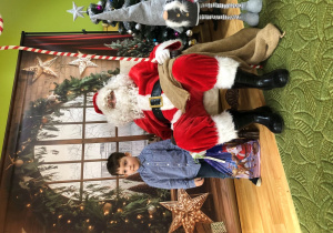 Dziecko pozuje do zdjęcia z Mikołajem