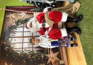 Dziecko pozuje do zdjęcia z Mikołajem