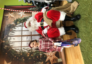 Dziecko pozuje do zdjęcia z Mikołajem
