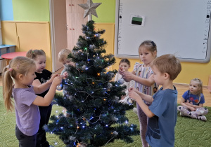 Dzieci ubierają choinkę
