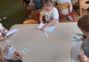 Dzieci wycinają paski z papieru