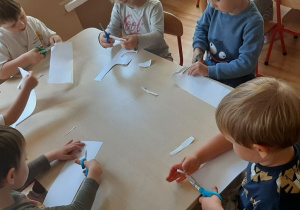 Dzieci wycinają paski z papieru