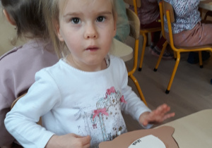 Dziewczynka wykonuje renifera z papieru