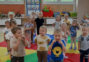 Dzieci biorą dział w zabawie stojąc na chuście animacyjnej