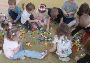 Dzieci bawią się klockami na dywanie