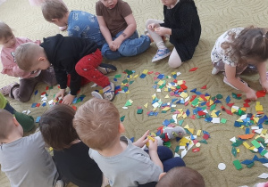 Dzieci bawią się klockami na dywanie