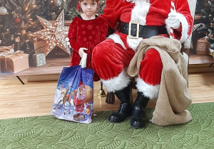 Dziecko pozuje do zdjęcia z Mikołajem