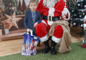 Dziecko pozuje do zdjęcia z Mikołajem