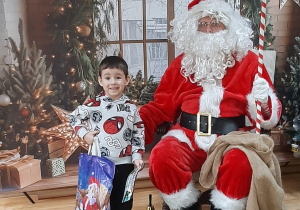 Dziecko pozuje do zdjęcia z Mikołajem