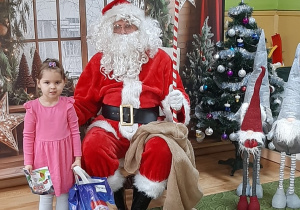 Dziecko pozuje do zdjęcia z Mikołajem