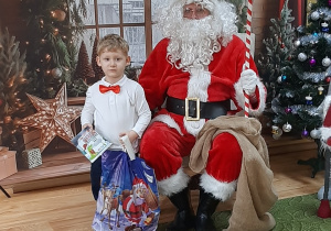Dziecko pozuje do zdjęcia z Mikołajem