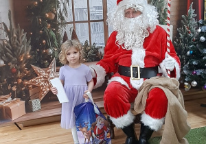Dziecko pozuje do zdjęcia z Mikołajem