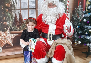 Dziecko pozuje do zdjęcia z Mikołajem