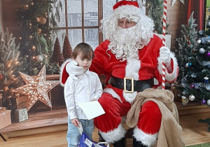 Dziecko pozuje do zdjęcia z Mikołajem