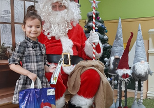 Dziecko pozuje do zdjęcia z Mikołajem