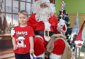 Dziecko pozuje do zdjęcia z Mikołajem