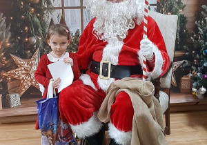 Dziecko pozuje do zdjęcia z Mikołajem