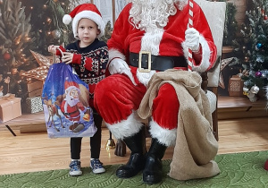 Dziecko pozuje do zdjęcia z Mikołajem