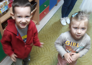 Chłopiec i dziewczynka pozują do zdjęcia w sali przedszkolnej