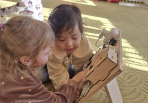 Dzieci bawią się tablicami manualno-sensorycznymi