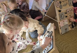 Dzieci bawią się tablicami manualno-sensorycznymi