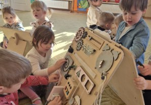 Dzieci bawią się tablicami manualno-sensorycznymi