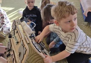 Dzieci bawią się tablicami manualno-sensorycznymi