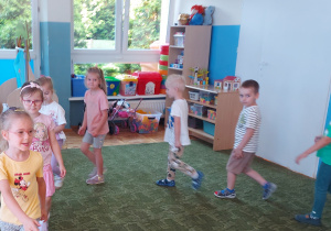 Dzieci maszerują po sali klaszcząc w ręce