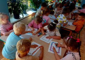 Dzieci wykonują pracę plastyczną pastelami
