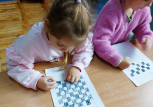 Dzieci kolorują szachownicę w ramach zajęć szachowych