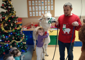 Dziewczynka przytula się do zwierzęcia