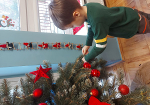 Dziecko ubiera choinkę