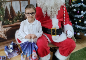 Dziecko pozuje do zdjęcia z Mikołajem