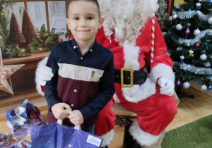 Dziecko pozuje do zdjęcia z Mikołajem