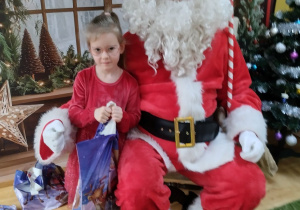 Dziecko pozuje do zdjęcia z Mikołajem