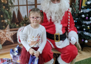 Dziecko pozuje do zdjęcia z Mikołajem