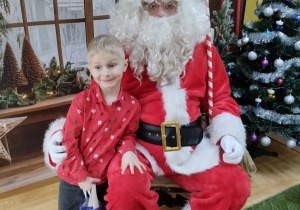 Dziecko pozuje do zdjęcia z Mikołajem