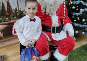 Dziecko pozuje do zdjęcia z Mikołajem