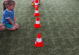 Dziewczynka turla piłkę w trakcie ćwiczeń gimnastycznych