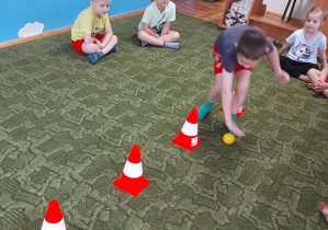 Chłopiec turla piłkę w trakcie ćwiczeń gimnastycznych