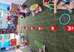 Dzieci ćwiczą rzut obręczą w trakcie ćwiczeń gimnastycznych