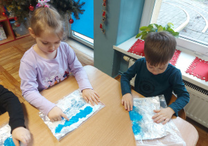 Dzieci malują paluszkami farbą umieszczoną w folii