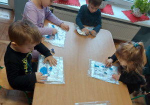 Dzieci malują paluszkami farbą umieszczoną w folii