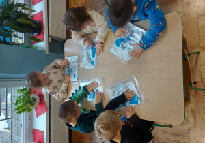 Dzieci malują paluszkami farbą umieszczoną w folii