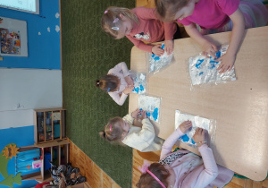 Dzieci malują paluszkami farbą umieszczoną w folii