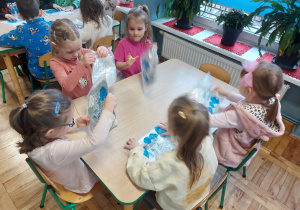 Dzieci malują paluszkami farbą umieszczoną w folii