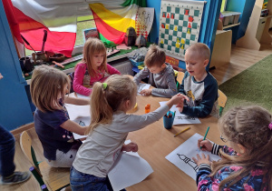 Dzieci kolorują gońca na kartce