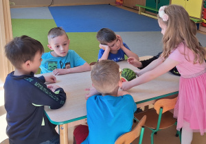 Dziewczynka częstuje dzieci owocami urodzinowymi