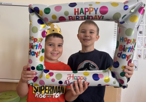 Chłopcy pozują do zdjęcia z urodzinową ramką