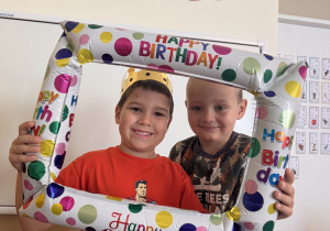 Chłopcy uśmiechają się do urodzinowego zdjęcia